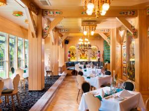 a restaurant with white tables and chairs and a chandelier at Best Western Ahorn Hotel Oberwiesenthal – Adults Only in Kurort Oberwiesenthal