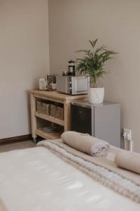 a room with a microwave and a table with a plant at Villa Rose Guesthouse & Venue in Bloemfontein