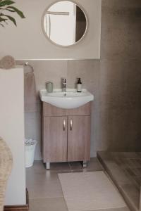 a bathroom with a sink and a mirror at Villa Rose Guesthouse & Venue in Bloemfontein