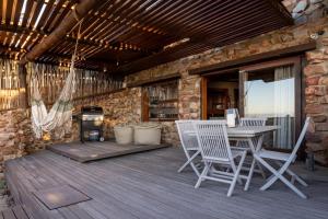 Un patio con mesa y sillas y una estufa. en Dolphin Sunrise, en Jeffreys Bay