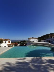 a swimming pool in a villa with a blue sky at Residence Chiaro di Luna in San Teodoro