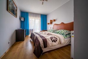 ein Schlafzimmer mit einem großen Bett und blauen Vorhängen in der Unterkunft Ośrodek Zacisze in Rozewie