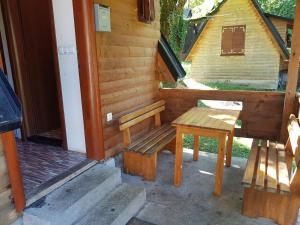 eine Bank und ein Tisch auf der Außenseite eines Hauses in der Unterkunft Bungalov DeLux in Konjic