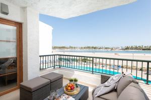 een woonkamer met een balkon met uitzicht op het strand bij Beachside Alcudia in Alcudia