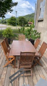 a wooden table and chairs on a deck at Appartement saisonnier in Bussang