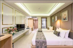 Habitación de hotel con 2 camas y TV en Jomtien Holiday Pattaya en Jomtien Beach