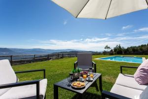 een patio met een tafel en stoelen en een zwembad bij Quinta da Bela vista in Celorico de Basto
