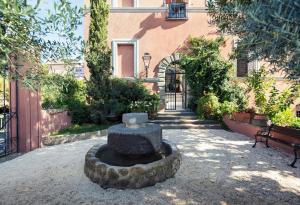 a stone fountain in a courtyard in front of a building at La Meridiana Relais in Formello