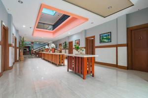 a lobby with a long counter in a building at Sans Hotel Budaya Cirebon in Cirebon