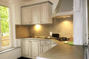 a kitchen with white cabinets and a sink and a stove at Le clos des maraîchers in Sainte-Savine +9 photos