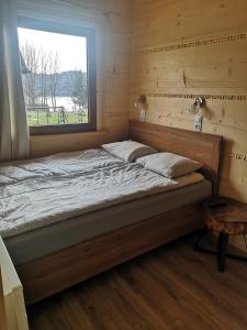 łóżko w pokoju z oknem w obiekcie DOMEK POD LIMBAMI V w Kluszkowcach