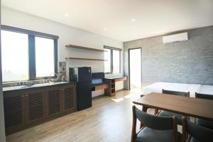 a bedroom with a bed and a table and a kitchen at LaLa Apartment and Hotel in Danang