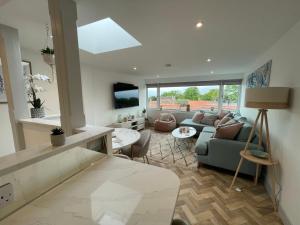 a living room with a couch and a tv at Lees Lookout Holt ,2 bedroom luxury apartment with private parking in Holt