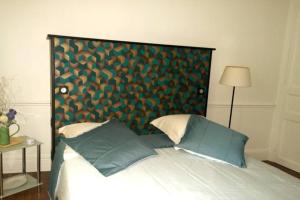 łóżko z zieloną deską z poduszkami w obiekcie Le clos des maraîchers w mieście Sainte-Savine