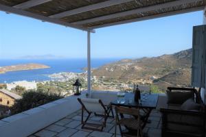 a view from the balcony of a house with a table and chairs at Salty Edge Holiday Home in Serifos Chora