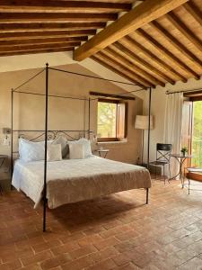 トレクアンダにあるAgriturismo Soleのベッドルーム1室(金属製の天蓋付きの大型ベッド1台付)