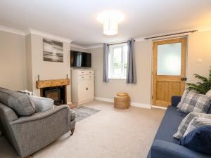 uma sala de estar com dois sofás e uma lareira em 3 The Cottages em Great Yarmouth