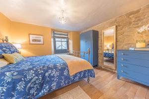 a bedroom with a blue bed and a stone wall at Self check in cosy country retreat in Lancaster