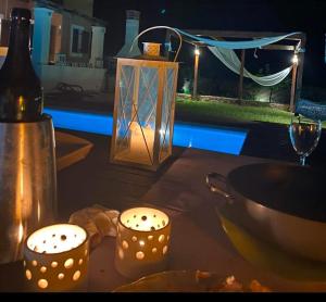 una mesa con dos velas y una botella de vino en Georges Villa Galaxidi, family, pool and garden, en Galaxidhion