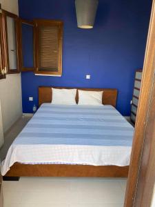 um quarto azul com uma cama com uma parede azul em Georges Villa Galaxidi, family, pool and garden em Galaxidi