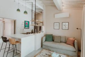 ein Wohnzimmer mit Sofa und eine Küche in der Unterkunft Borgo 69 Villas & Suites in Foiano della Chiana
