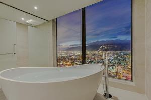 un bagno con vasca e ampia finestra di Le Sands Oceanfront Danang Hotel a Da Nang
