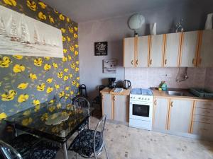 a kitchen with a table with yellow flowers on the wall at Apartment Martin in Šilo