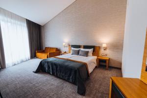 ein Hotelzimmer mit einem Bett und einem Stuhl in der Unterkunft Gabija Hotel SPA & Conferences in Palanga + 168 Fotos