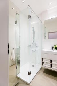 bagno con doccia in vetro e lavandino di Budapest Hercegprímás Apartments a Budapest
