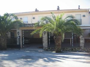 a building with two palm trees in front of it at Hostal El Sevillano in Rus