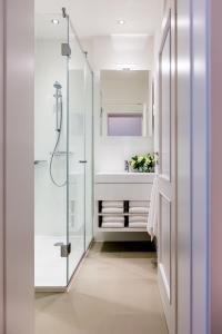 bagno bianco con lavandino e doccia di Budapest Hercegprímás Apartments a Budapest