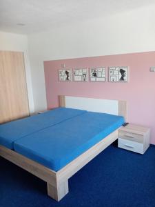 ピーセクにあるManhattan Penzionのベッドルーム1室(青いマットレス付きの大型ベッド1台付)