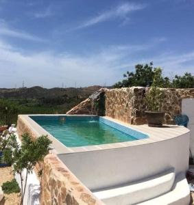 a swimming pool on top of a stone wall at Quinta Vale de Luz in Silves