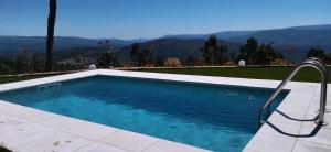 a swimming pool with a view of the mountains at Bungalow com piscina in Celorico de Basto