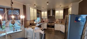 a kitchen with white cabinets and a blue refrigerator at Ocean Front Villa in Vogar