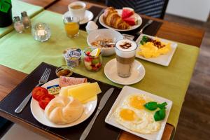- une table avec des assiettes de produits pour le petit-déjeuner et des boissons dans l'établissement Hotel Princess Self Check-In, à Plochingen