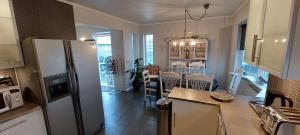 a kitchen with a refrigerator and a dining room at Ocean Front Villa in Vogar +18 photos