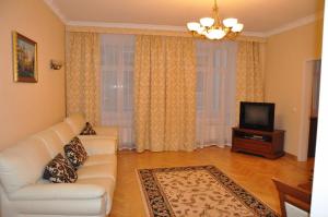a living room with a white couch and a television at Old Town Apartments in Lviv