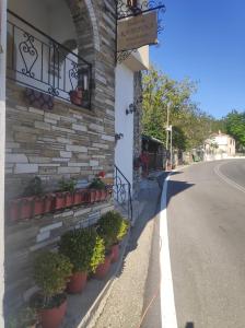 Catherine Portaria Guest House في بورتاريا: مبنى به نباتات الفخار على جانب الشارع