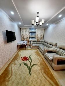 sala de estar con sofá y TV en 2 комнатная квартира Назавбаева 34, en Pavlodar