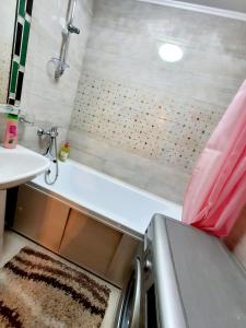y baño con bañera y lavamanos. en 2 комнатная квартира Назавбаева 34, en Pavlodar