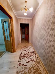 un pasillo vacío con una puerta y una alfombra en 2 комнатная квартира Назавбаева 34, en Pavlodar