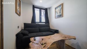 Una sala de estar con un sofá y una mesa de madera. en Chez Rémy, en Les Angles