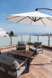 een patio met 2 stoelen, een tafel en een parasol bij Hotel Lero in Dubrovnik