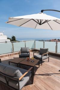 a patio with two chairs and a table and an umbrella at Hotel Lero in Dubrovnik