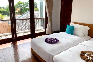 sypialnia z 2 łóżkami i fioletowym kwiatem w obiekcie Farmers Villa CoLiving Space w mieście Mae Nam