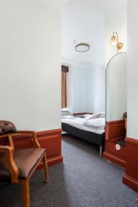 a bedroom with a bed and a chair and a mirror at Hotell Skeppsbron in Stockholm