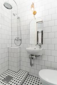 a white bathroom with a sink and a toilet at Hotell Skeppsbron in Stockholm