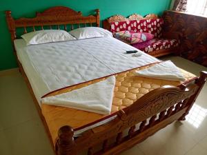 uma grande cama de madeira num quarto com um sofá em BIOVILLAS em Yelagiri