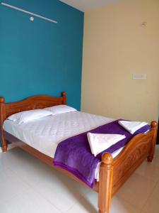 uma cama com uma estrutura de madeira num quarto em BIOVILLAS em Yelagiri